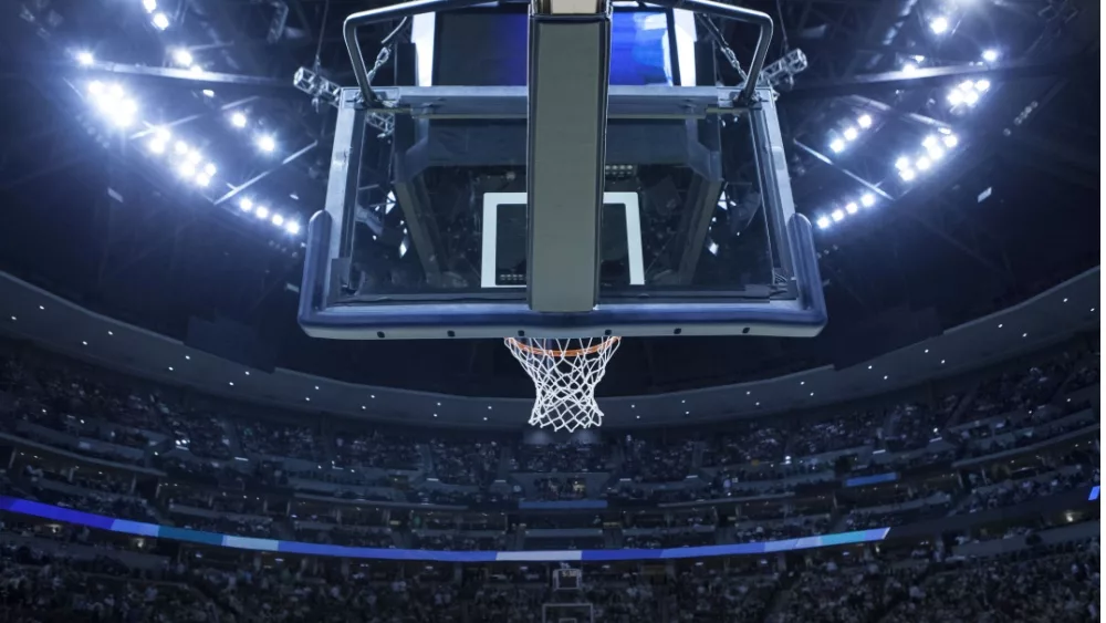 Brightly lit Basketball backboard in a large sports arena.