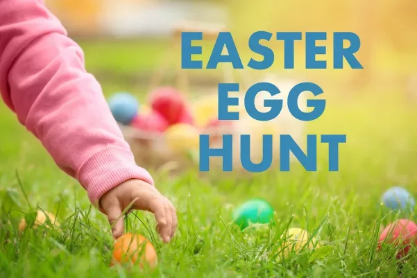 arm of child reaching for colored plastic egg in grass with the text "EASTER EGG HUNT" in blue