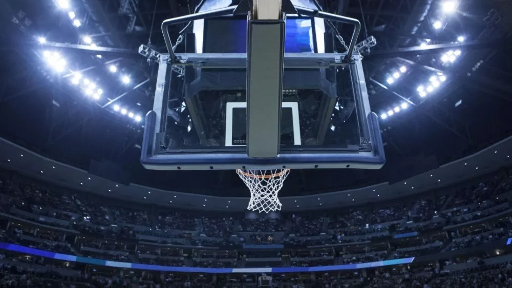 Brightly lit Basketball backboard in a large sports arena.