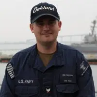 U.S. Navy Petty Officer 3rd Class Kolby Ryan^ a 2021 Knoxville High School graduate^ stands aboard USS Oakland while wearing an Oakland ball cap and navy working uniform. (Photo: U.S. Navy)