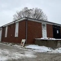 Old Hawthorne Warehouse at 2150 Veterans Drive^ Galesburg – brick industrial building with multiple garage doors^ now listed for sale by Galesburg CUSD 205.