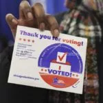 FILE - A voter shows her "I voted" sticker after casting her ballot in Chicago^ March 19^ 2024. (AP Photo/Teresa Crawford^ File)