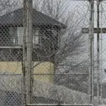 FILE - Security fences surround the Illinois Department of Corrections' Logan Correctional Center on Nov. 18^ 2016^ in Lincoln^ Ill. A report Tuesday^ Sept. 20^ 2022^ by a state inspector general found that an Illinois prison system administrator improperly ordered the hiring of a family member for a Department of Corrections position that was never authorized. (AP Photo/Seth Perlman^ File)