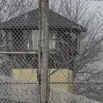 FILE - Security fences surround the Illinois Department of Corrections' Logan Correctional Center on Nov. 18^ 2016^ in Lincoln^ Ill. A report Tuesday^ Sept. 20^ 2022^ by a state inspector general found that an Illinois prison system administrator improperly ordered the hiring of a family member for a Department of Corrections position that was never authorized. (AP Photo/Seth Perlman^ File)