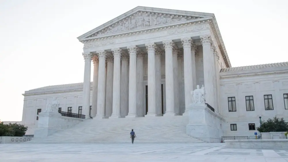 A man climbs the steps of the Supreme Court of America in Washington DC.Washington DC^ USA - August 14^ 2018