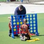 IMAGE: Gov. JB Pritzker plays Connect 4 with children following an event to open a new sports park in Springfield on April 28^ 2026. (Capitol News Illinois photo by Jerry Nowicki)