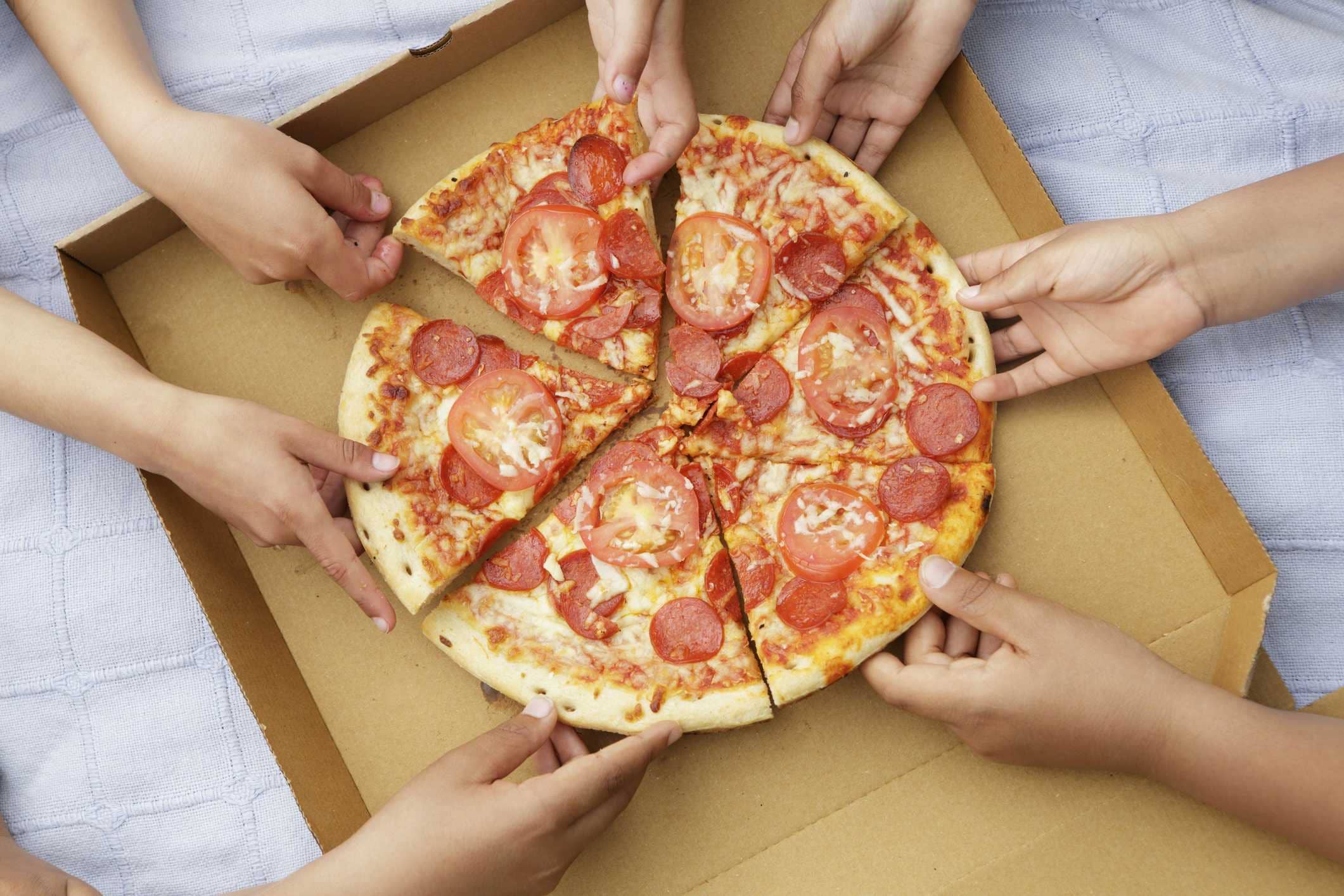 childrens-hands-taking-pizza-slices-out-or-high-res-stock-photography-591394853-1548187732558013