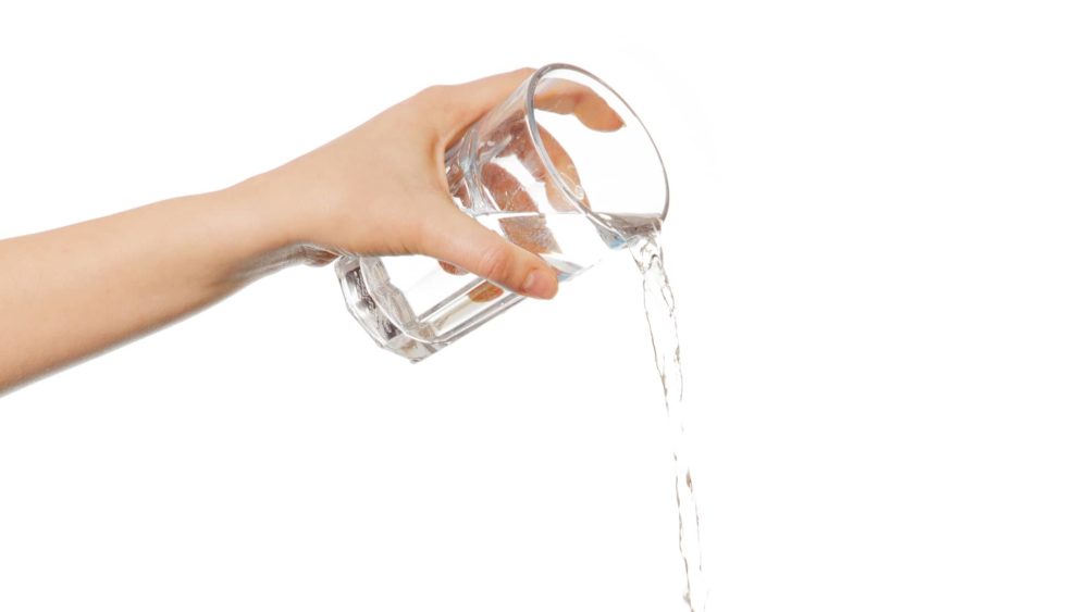 close-up-of-woman-pouring-water-against-white-background