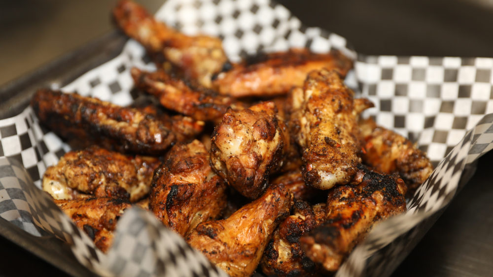 pile-of-grilled-organic-chicken-wings-ready-to-be-tossed-into-bbq-sauce