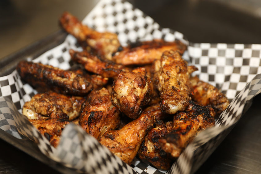 pile-of-grilled-organic-chicken-wings-ready-to-be-tossed-into-bbq-sauce