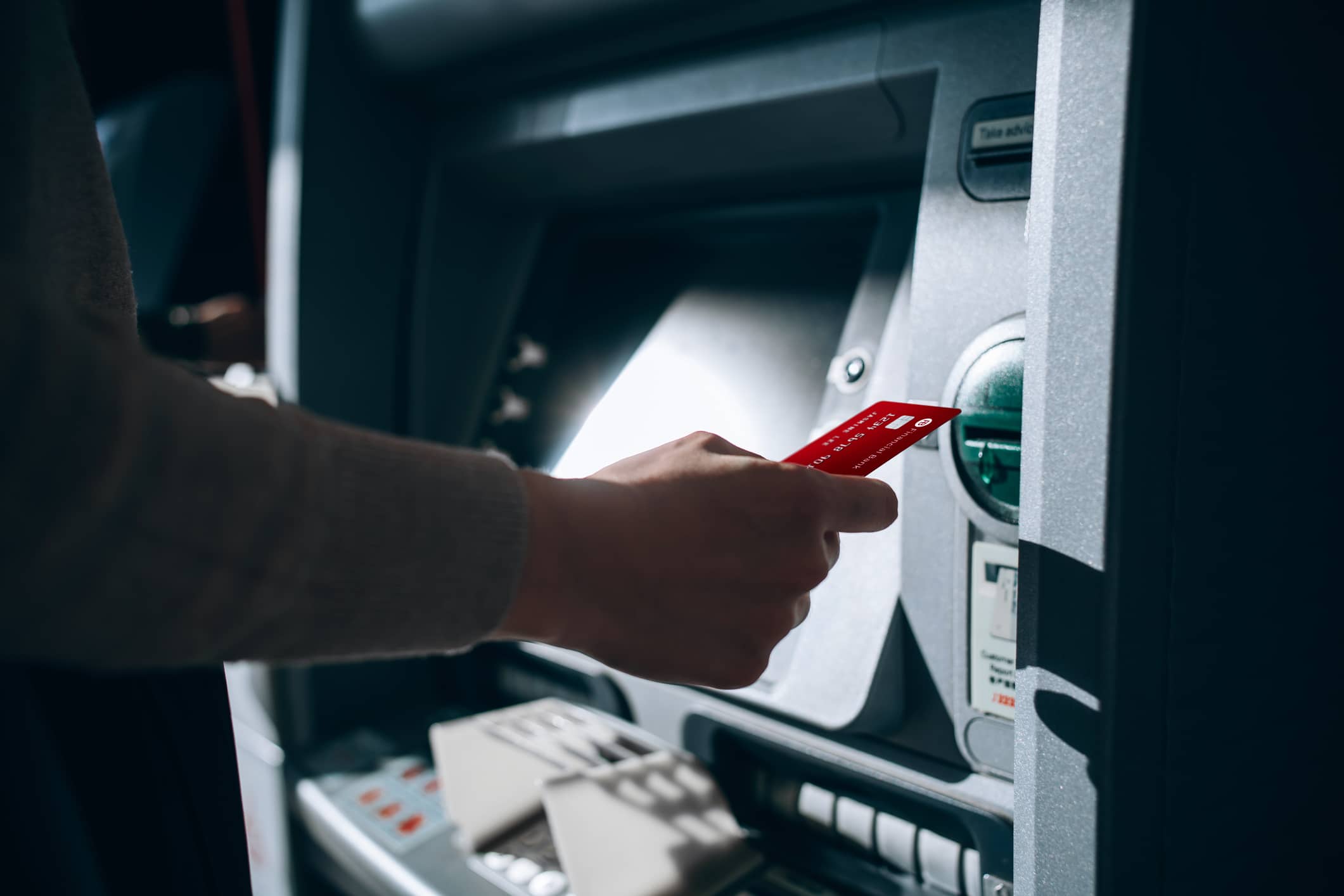 close-up-of-young-woman-inserting-her-bank-card-into-automatic-cash-machine-in-the-city-withdrawing-money-paying-bills-checking-account-balances-transferring-money-privacy-protection-internet-an