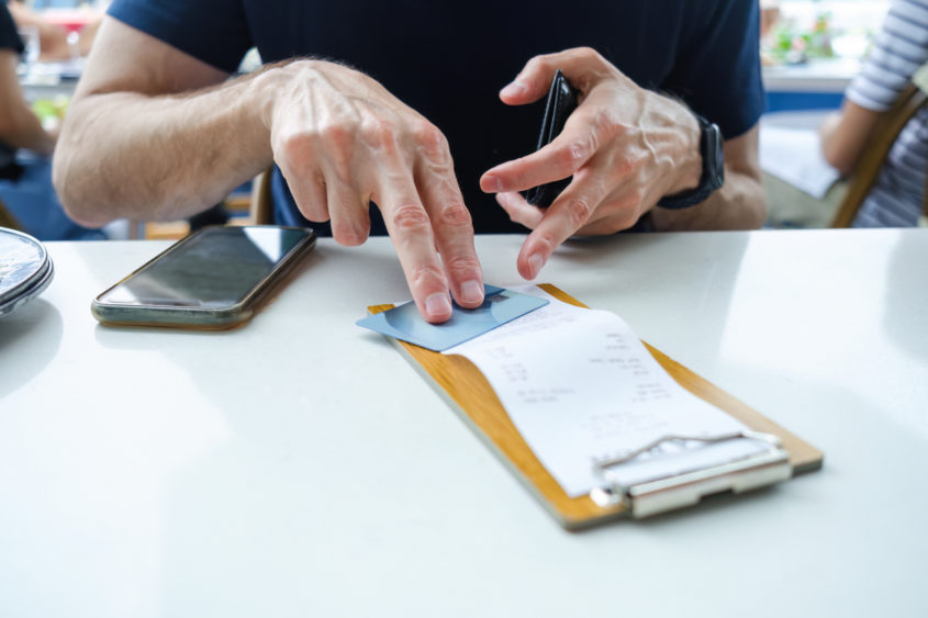 man-prepares-to-pay-restaurant-bill-with-credit-card