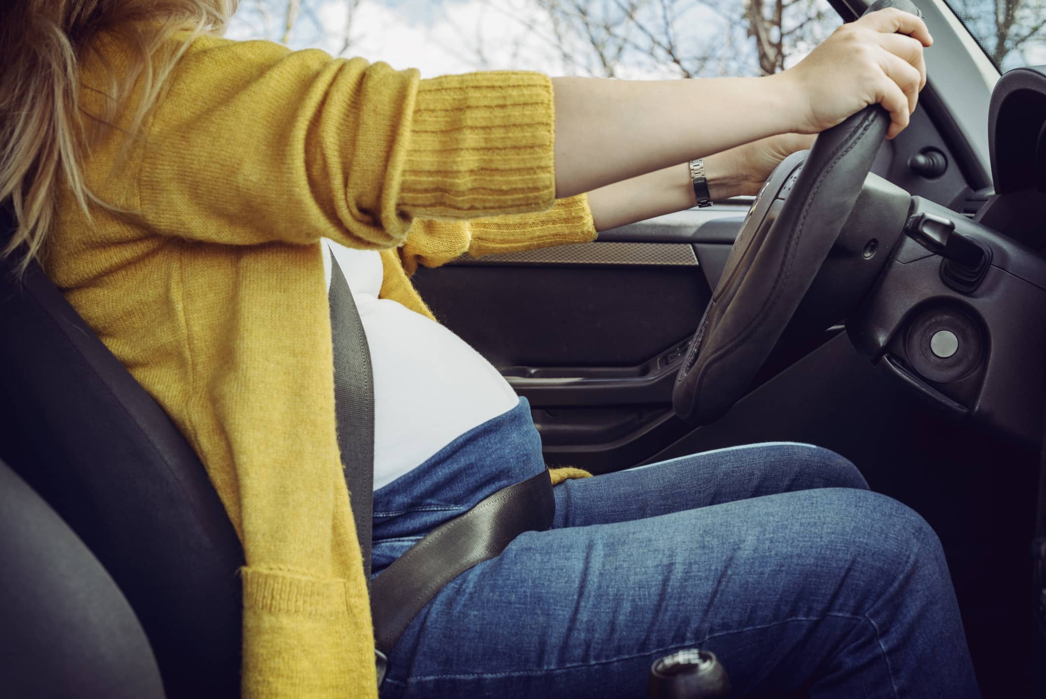 pregnant-woman-fastening-safety-belt-in-car