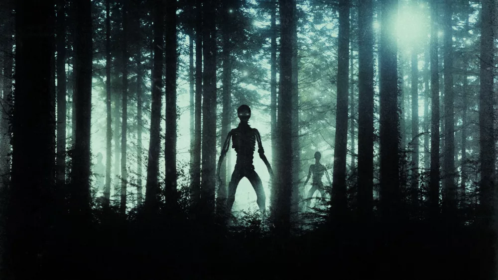 horror-sci-fi-concept-of-alien-monsters-standing-in-a-forest-silhouetted-by-bright-ufo-lights-at-night