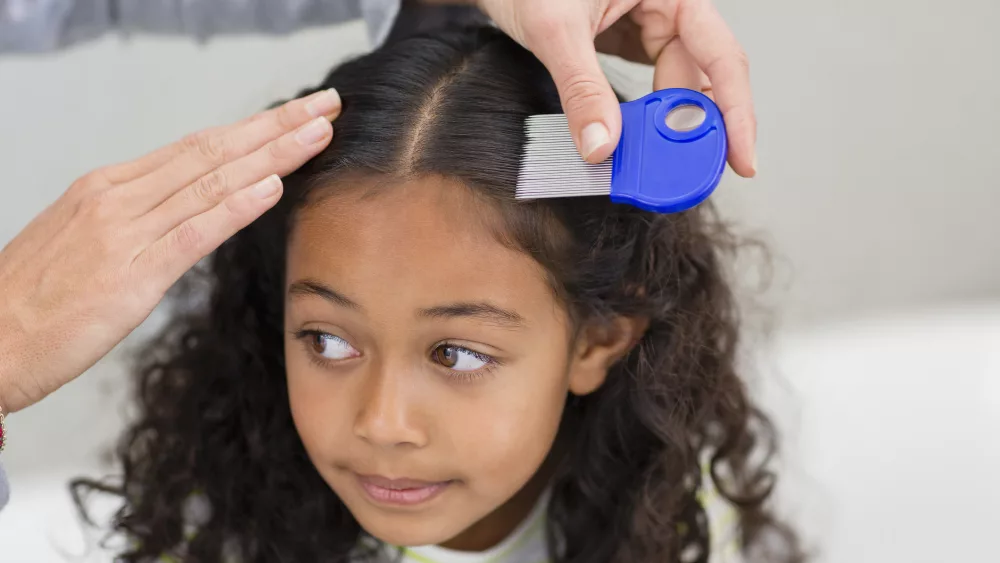 mother-using-lice-comb-on-daughters-hair