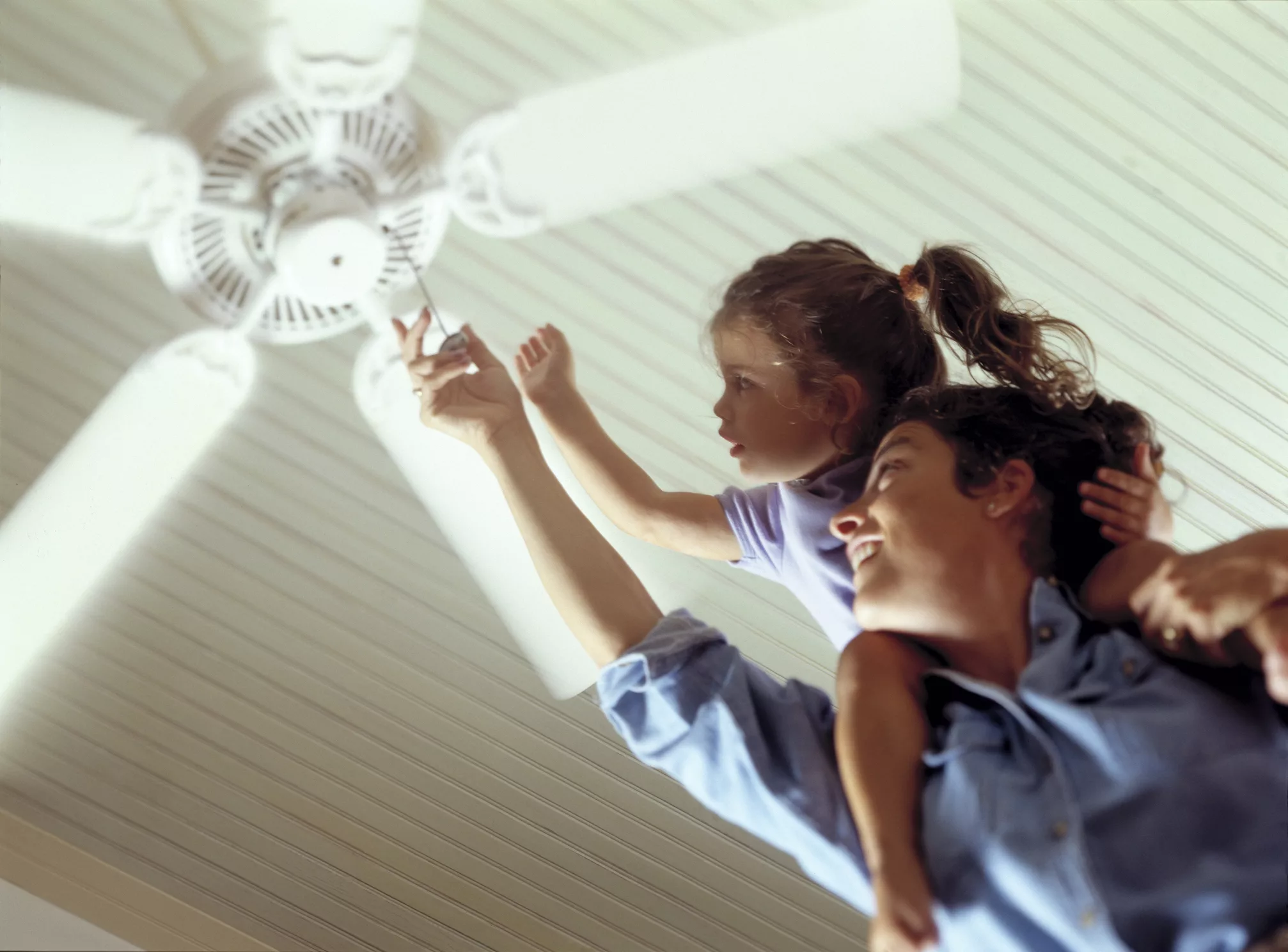 mother-and-daughter-turning-on-a-celing-fan