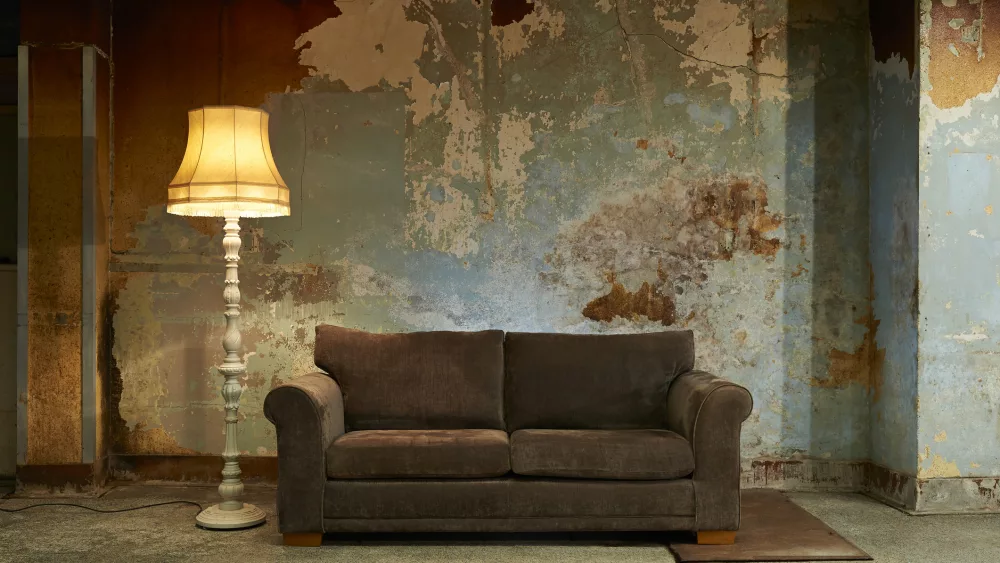 old-sofa-and-vintage-floor-lamp-in-decaying-room