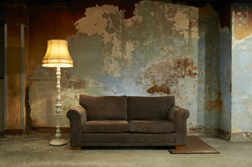 old-sofa-and-vintage-floor-lamp-in-decaying-room