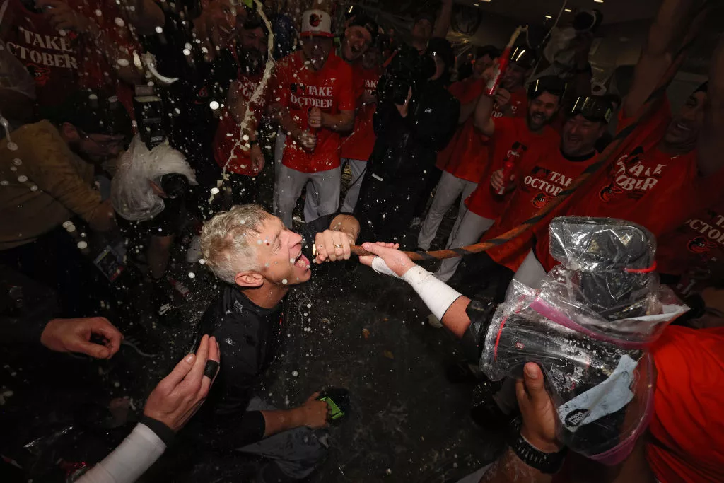 SEPTEMBER 17: Executive Vice President and General Manager Mike Elias of the Baltimore Orioles drinks from the 'Homer Hose' as his team celebrates in the clubhouse after the Baltimore Orioles clinched a 2023 MLB playoff berth after defeating the Tampa Bay Rays at Oriole Park at Camden Yards on September 17, 2023 in Baltimore, Maryland. (Photo by Patrick Smith/Getty Images)