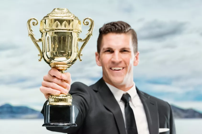 smiling-businessman-holding-trophy