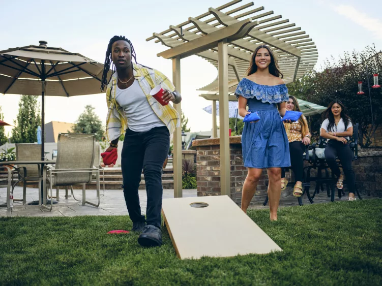 backyard-party-playing-cornhole-bean-bag-toss-game