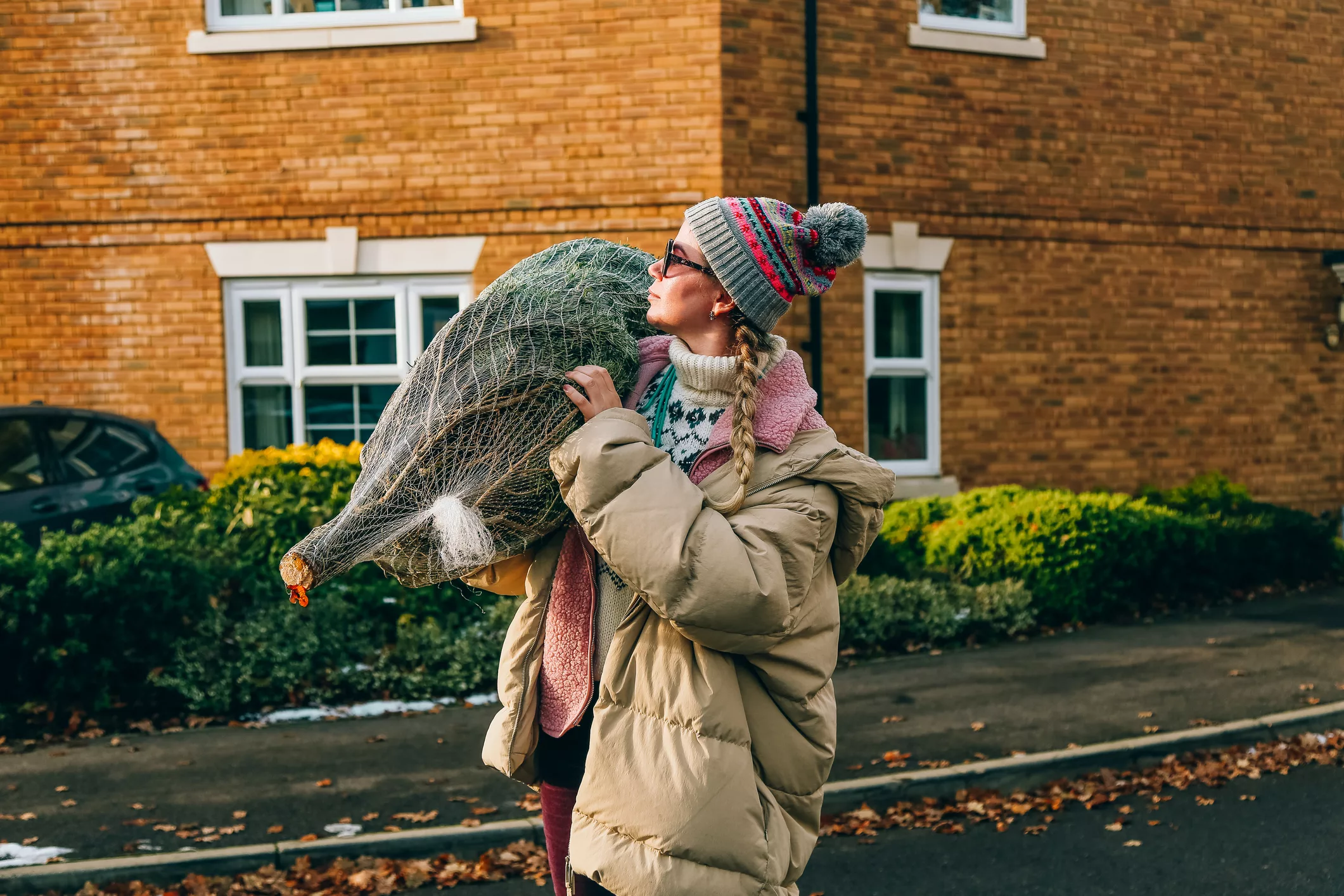 woman-carrying-a-christmas-tree-on-a-street