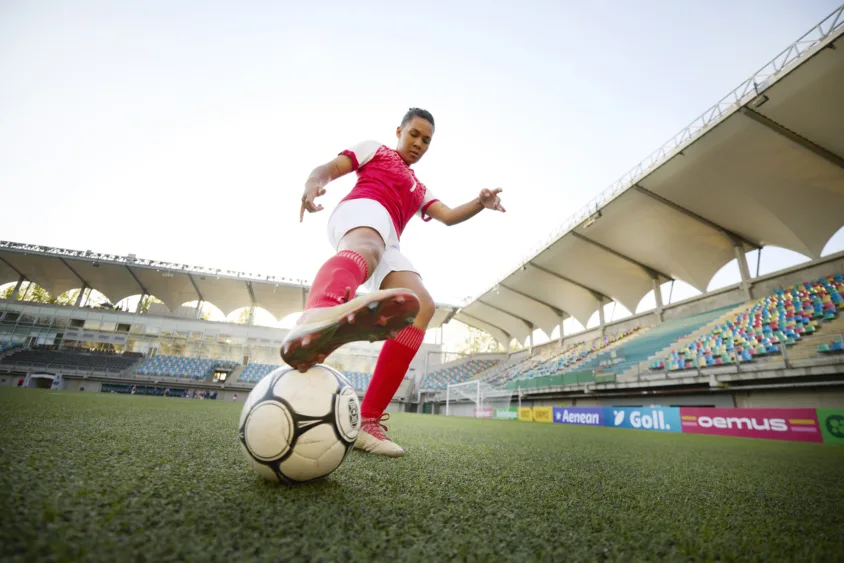 low-angle-photograph-of-active-woman-soccer-player-reaching-leg-towards-ball