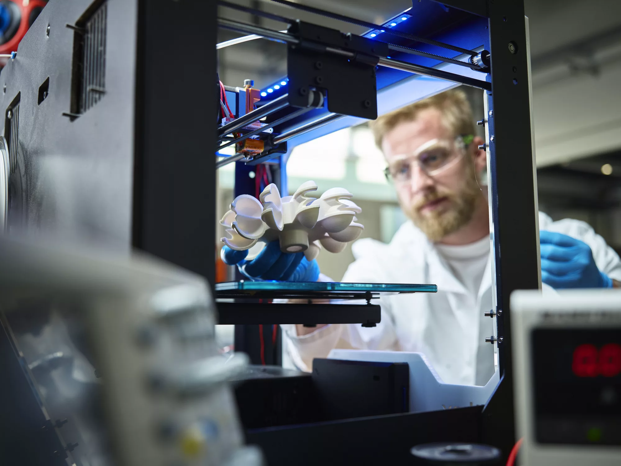 technician-with-turbine-wheel-being-printed-in-3d-printer