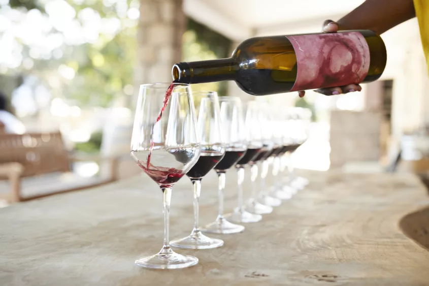 hand-of-female-owner-pouring-red-wine