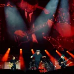 AC/DC Power Up Tour - Start of the European tour: 17 May 2024, North Rhine-Westphalia, Gelsenkirchen: AC/DC Power Up Tour - start of the German tour, Veltins Arena. Brian Johnson (M), singer, sings while Angus Young, lead guitarist, can be seen on the video screen. Photo: Bernd Thissen/dpa (Photo by Bernd Thissen/picture alliance via Getty Images)