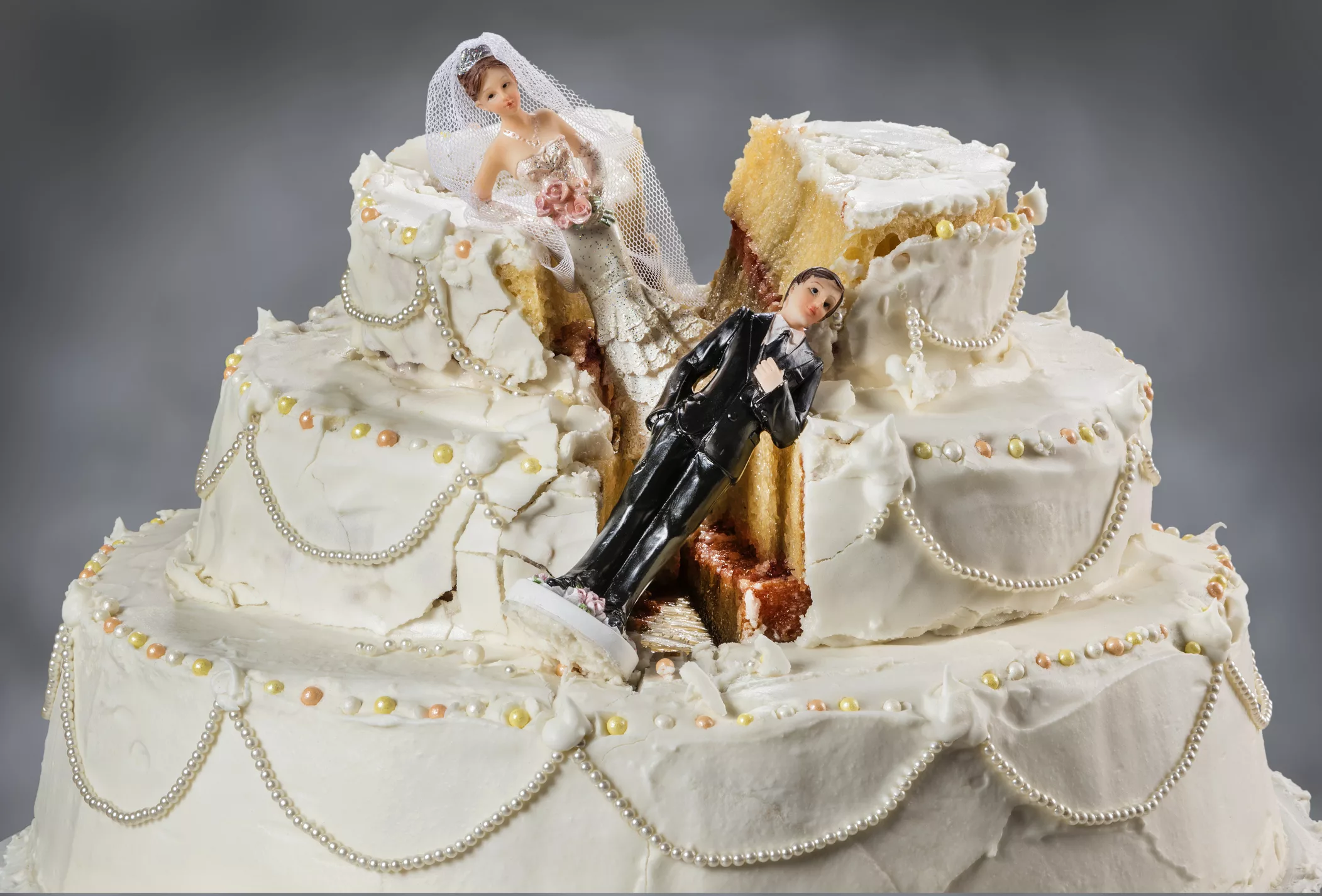 bride-and-groom-figurines-collapsed-at-ruined-wedding-cake