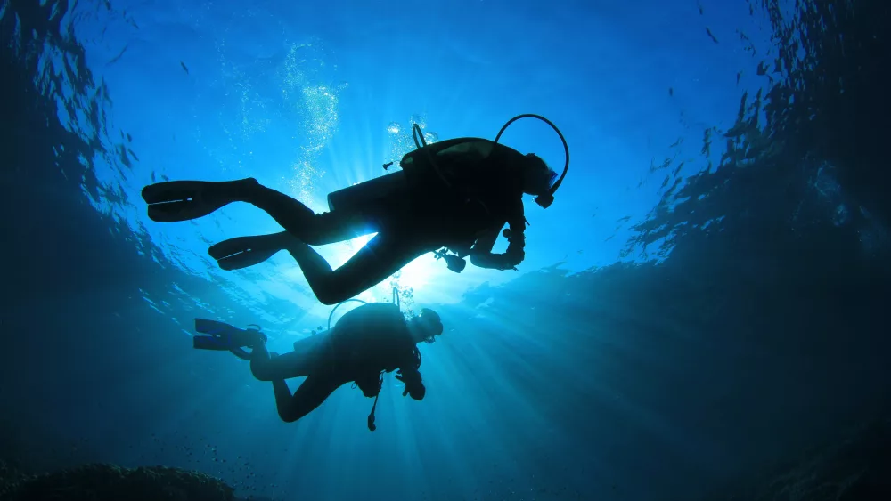 two-people-scuba-diving-with-sunlight-from-above