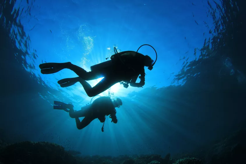 two-people-scuba-diving-with-sunlight-from-above