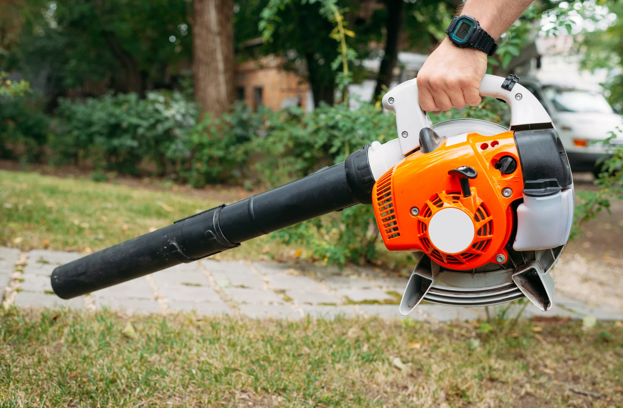 green-lawn-cleaning-with-an-electric-cordless-air-blower-from-colorful-fallen-leaves