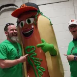 relish1: Justin Schlegel, Amelia Ryerse and the Orioles' Relish Condiment Mascot pose ahead of the June 28 98 Rock Night Hot Dog Race. (Photo Credit: Katarina Hein - Hearst)