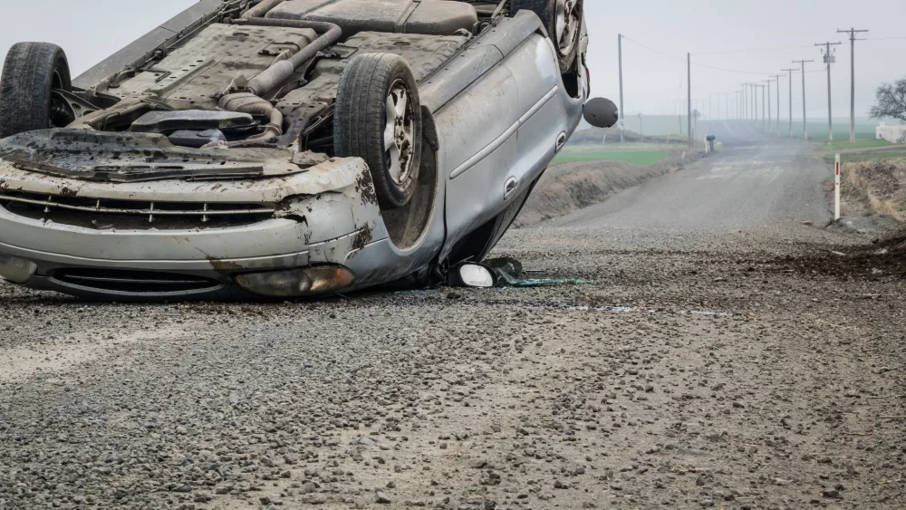 an-overturned-car-on-a-rural-road