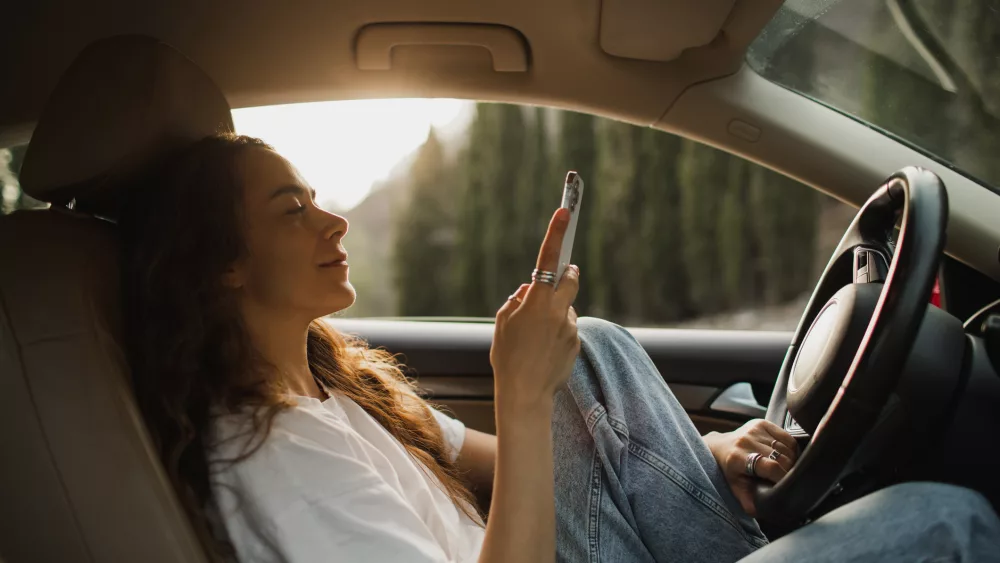 woman-relaxing-in-car-at-sunset-and-wasting-time-on-social-media-in-smartphone