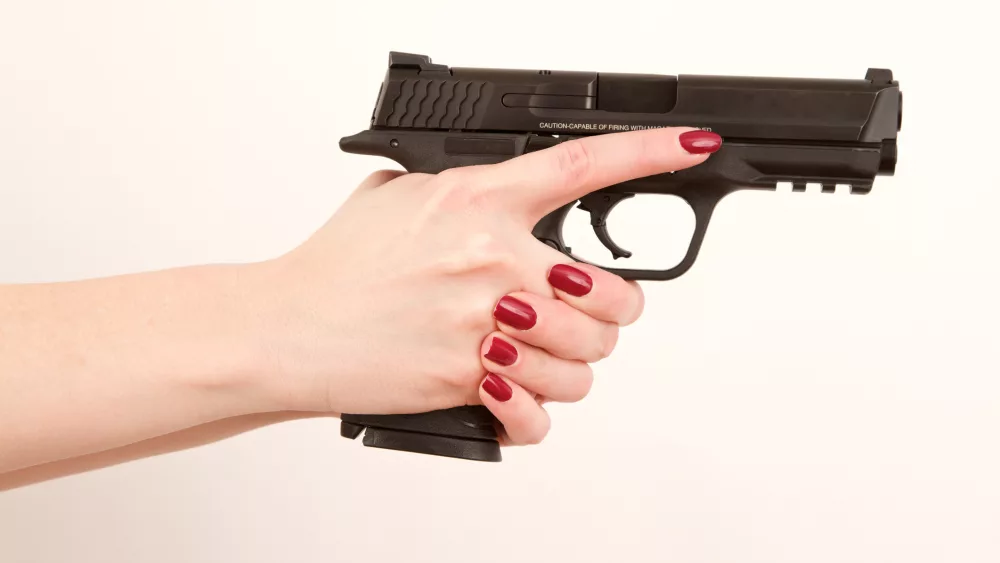 woman-holding-pistol-finger-off-trigger