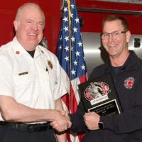 Galesburg Fire Chief presents Captain Matthew Cain with the 2023 Firefighter of the Year award.