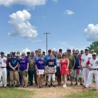 Former players^ family and friends pose for a photo following a naming dedication ceremony of Coach Jimmy Isaacson Field on Sunday^ July 21^ 2024^ at H.T. Custer Park.