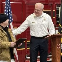 Galesburg resident Joseph Lamnert receives a Civic Excellence Award from Galesburg Fire Chief Randy Hovind during a ceremony Wednesday^ Feb. 19^ 2025^ at Central Fire Station. (JAY REDFERN/WGIL)