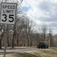 35 mph speed limit sign on South Lake Storey Road in Galesburg^ Illinois^ with a vehicle approaching^ highlighting traffic concerns on the road.