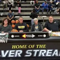 Marla Clay^ Brett Wolfe^ Jeanine Bryant^ and Jeff Lamb seated at the scorer's table at Galesburg High School's Thiel Gym