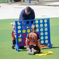 Gov. JB Pritzker plays Connect 4 with children following an event to open a new sports park in Springfield on April 28^ 2026.