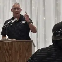 Shawn Hickey speaking at a podium during the Western Big 6 football kickoff banquet