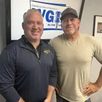 Randy Bryan and Jeff Maher standing in front of the WGIL logo