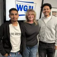 Diego dos Santos Branco Martinez^ Jeannie Weber^ and Caio Oliveira stand in front of a WGIL logo screen in the station's studio