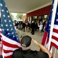 State Rep. Dan Swanson^ Woodhull^ salutes as the flag-draped casket of Cpl. Paul Hoots is loaded into a hearse Thursday^ July 24^ 2025^ at Hinchliff-Pearson-West Funeral Directors in Galesburg.