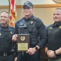 Galesburg Police Officer Noah Harlan^ center^ is the 2024 Galesburg Area CrimeStoppers Officer of the Year. Also pictured are Galesburg Police Chief Kevin Legate^ left^ and Knox County Sheriff Jack Harlan. (WGIL)