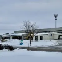 Snow-covered view of the Hollow Tree Apartments sign and the YMCA building along West Carl Sandburg Drive in Galesburg^ Illinois^ under cloudy skies on Sunday^ Nov. 30^ 2025.